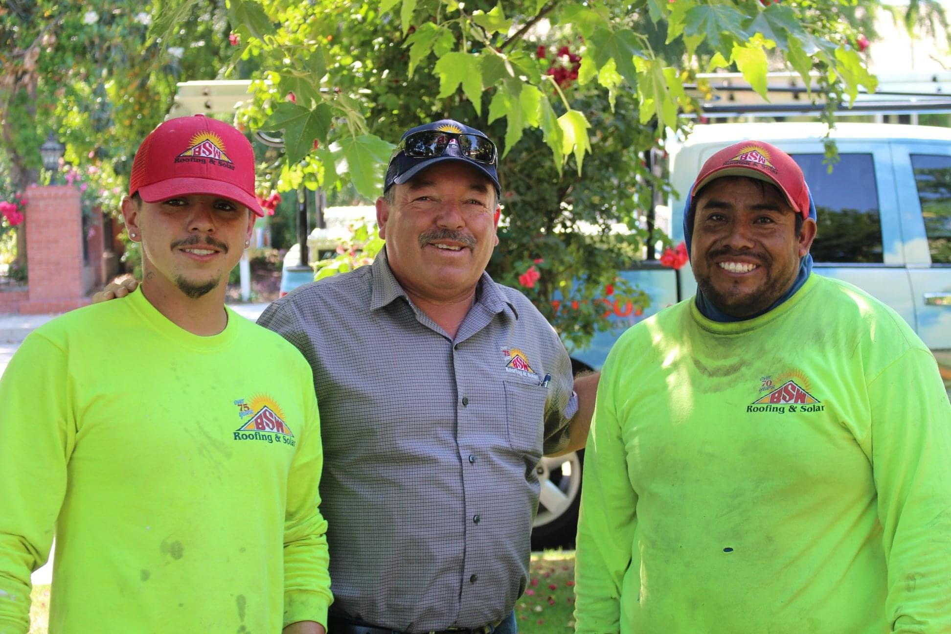 Three smiling BSW crew members in front of their truck
