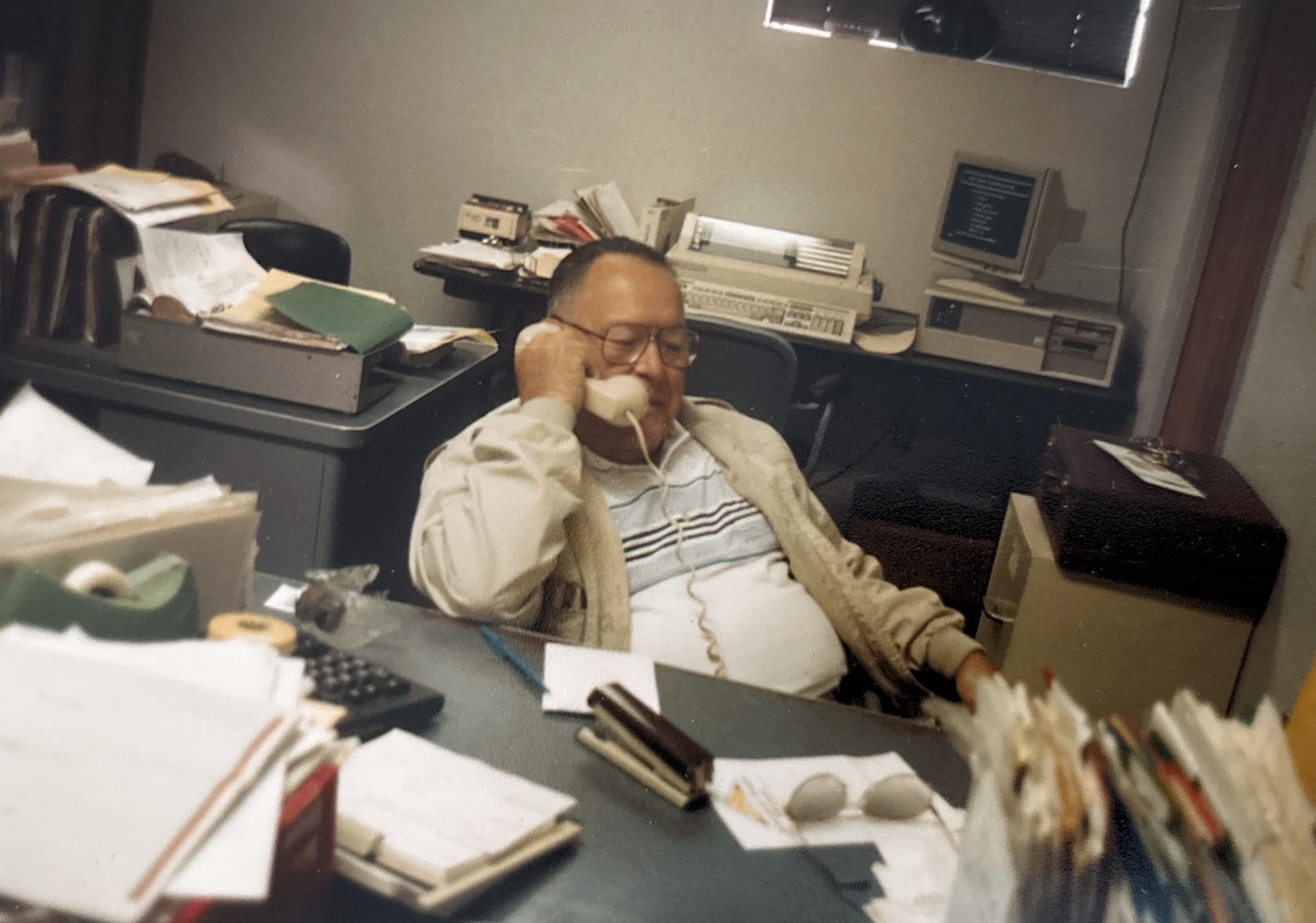 Ernest Montoya at his desk on the phone in the BSW office
